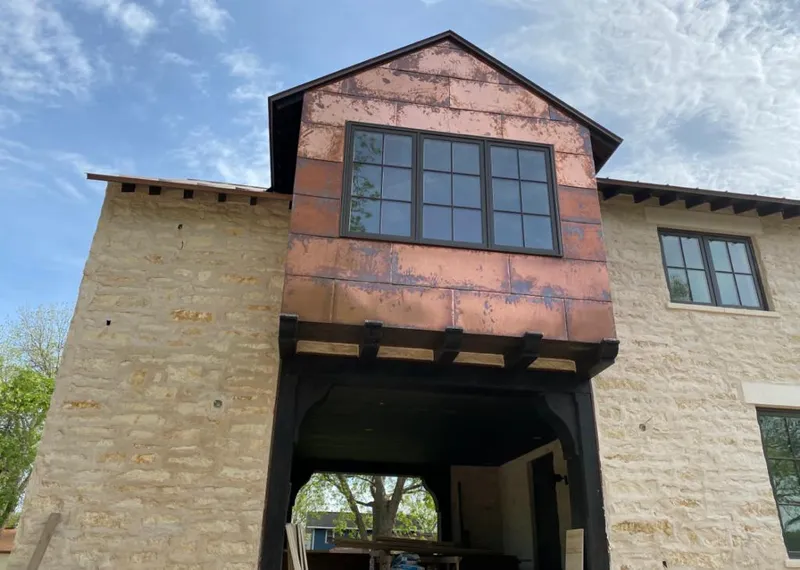 Copper metal panel facade on a stone building for Skylight Installation in Willow Oak